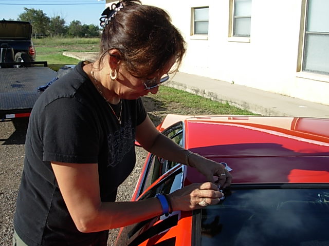 Sylvia applying Smoking Devil sticker in Marathon